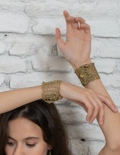 Brazalete Tomoe de ganchillo dorado, tejido a mano con hilo metalizado. Inspirado en las valientes guerreras japonesas, combina tradición y elegancia en una pieza artesanal única. Joyería ligera y sostenible con nombre propio.