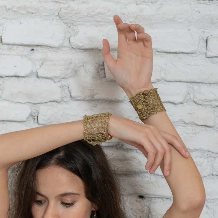 Brazalete Tomoe de ganchillo dorado, tejido a mano con hilo metalizado. Inspirado en las valientes guerreras japonesas, combina tradición y elegancia en una pieza artesanal única. Joyería ligera y sostenible con nombre propio.