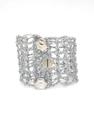Brazalete Tomoe de ganchillo plateado, tejido a mano con hilo metalizado. Inspirado en las valientes guerreras japonesas, combina tradición y elegancia en una pieza artesanal única. Joyería ligera y sostenible con nombre propio.