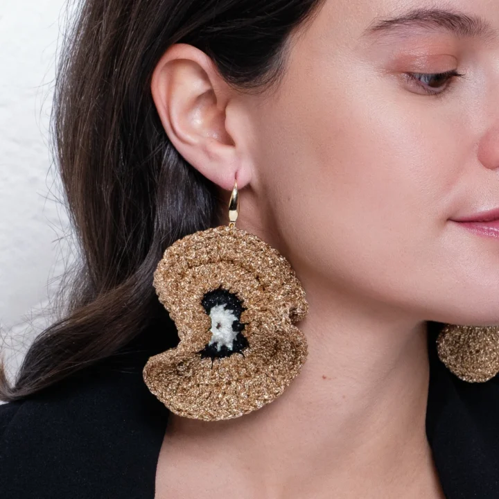 Mujer con pendientes Nereida Neptuno de Bemeknes. Color dorad, negro y blanco