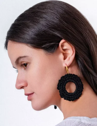 Pendientes bohemios de crochet negro en forma de círculo, añadiendo un toque handmade y elegante al outfit.
