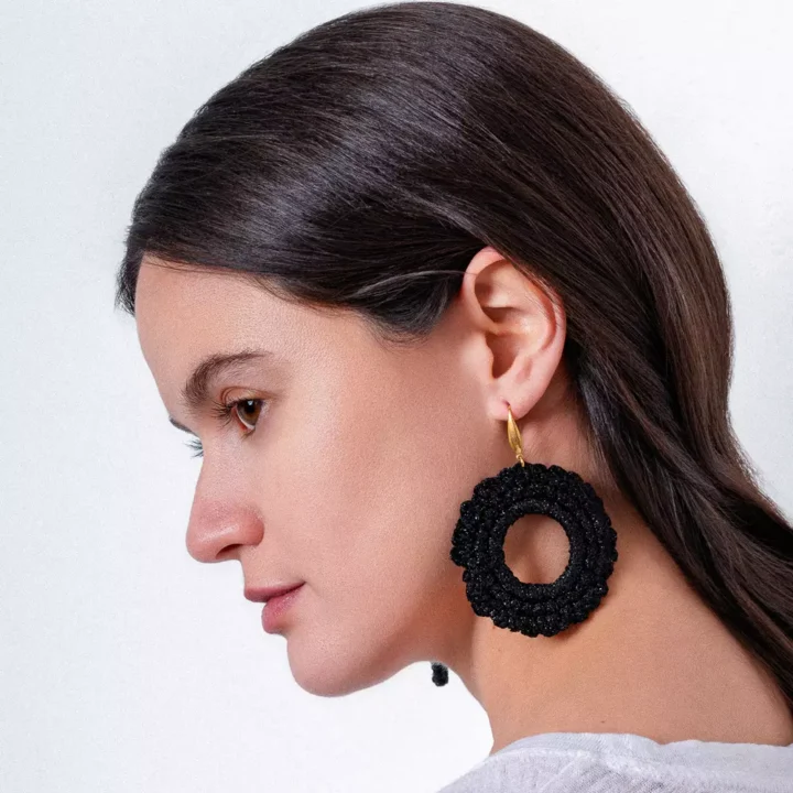 Pendientes bohemios de crochet negro en forma de círculo, añadiendo un toque handmade y elegante al outfit.