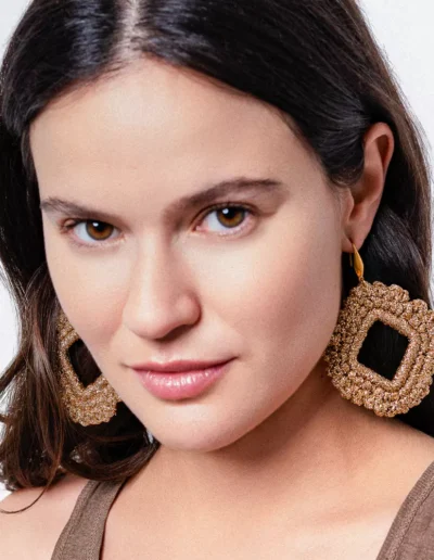 Mujer con pendientes rombo dorados artesanales Bemeknes