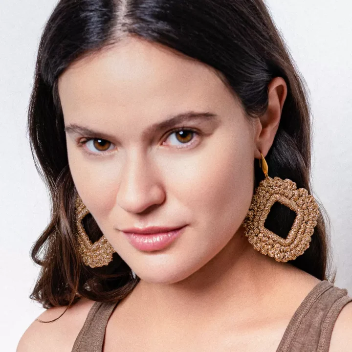 Mujer con pendientes rombo dorados artesanales Bemeknes