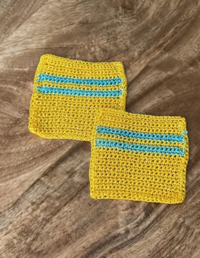 Detalle del posavaso cuadrado artesanal amarillo con franjas esmeralda.