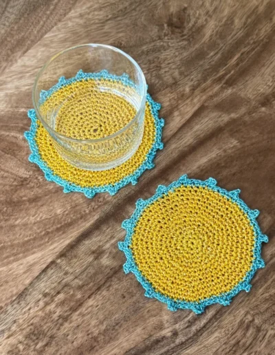 Posavasos Redondo Amarillo decorando una mesa con vaso de cristal
