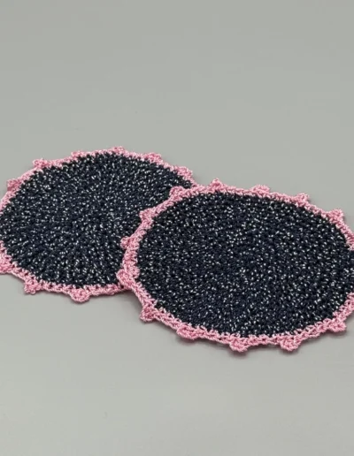 Detalle del posavaso artesanal azul marino con ribete rosa.