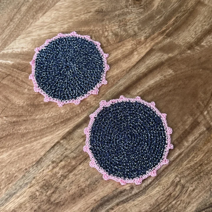 Posavasos Redondo Azul Marino tejidos a mano en azul marino con ribete rosa.