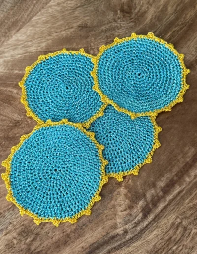 Detalle del posavaso Redondo Celeste artesanal con borde amarillo.