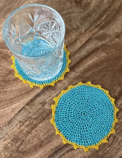 Posavasos Redondo Celeste decorando una mesa con vaso de cristal