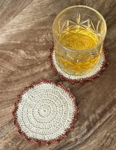 Posavasos Redondo Cobre decorando una mesa con un vaso de cristal