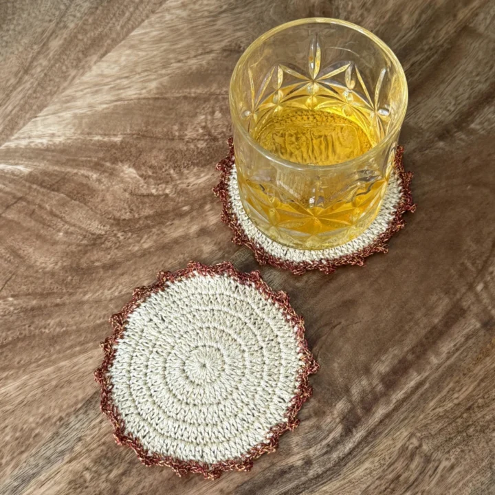 Posavasos Redondo Cobre decorando una mesa con un vaso de cristal