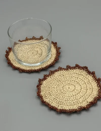 Posavasos Redondo Cobre decorando una mesa con un vaso de cristal pequeño