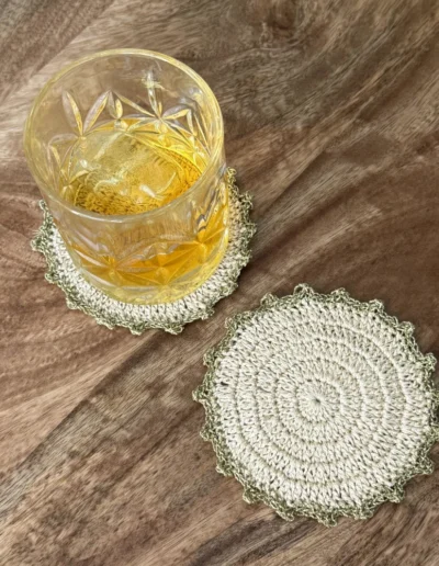Posavasos Redondo Oro decorando una mesa con vaso de cristal.